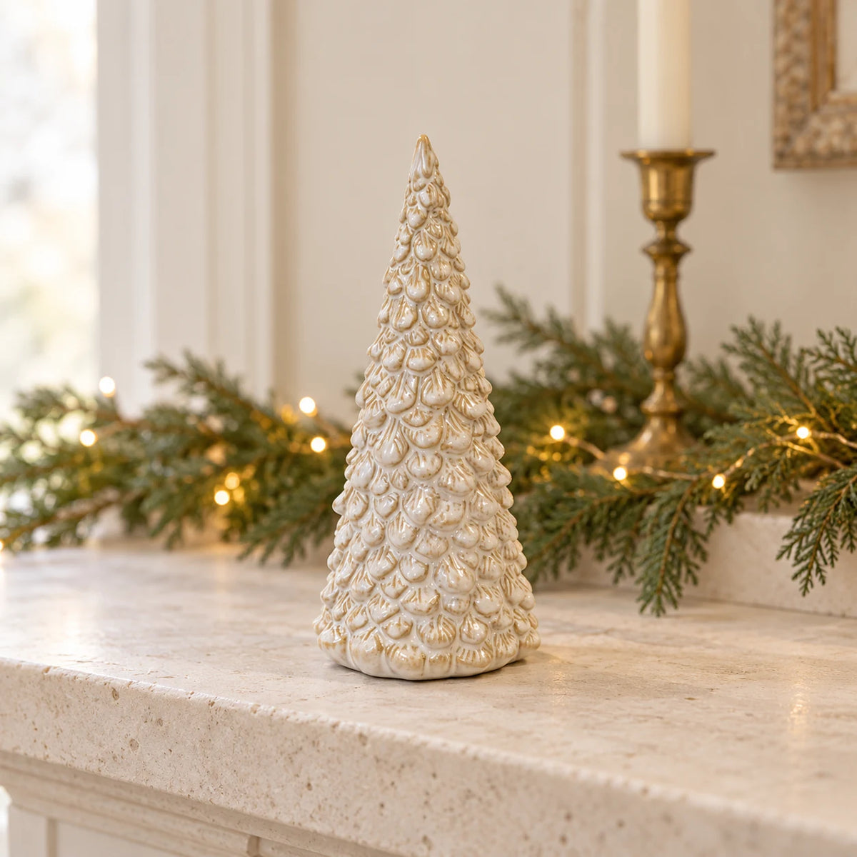 Cream layered ceramic Christmas tree styled on a pale stone mantel