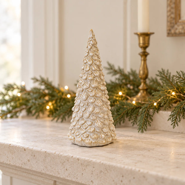 Cream layered ceramic Christmas tree styled on a pale stone mantel
