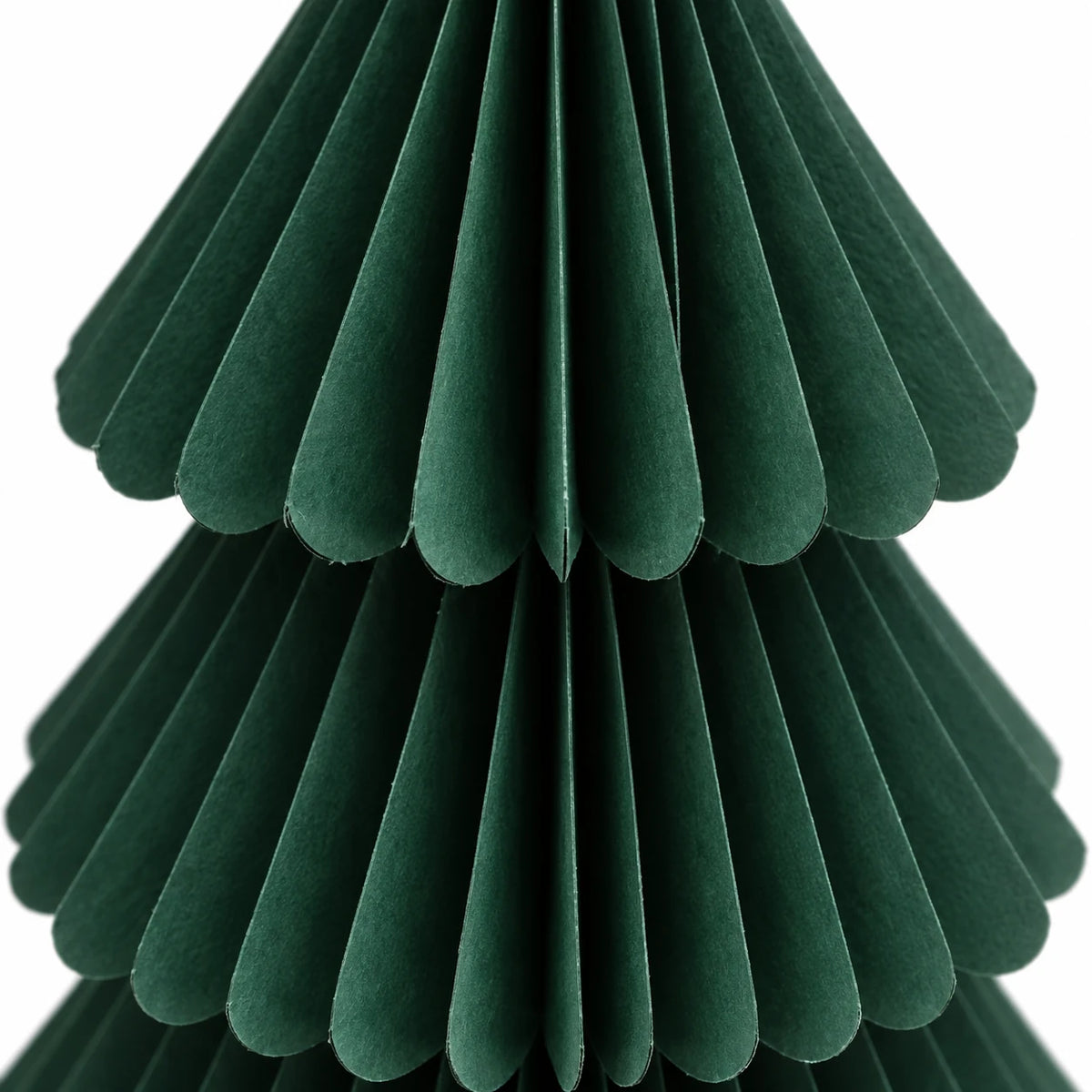 Close-up of dark green paper folds and scalloped tier edges.