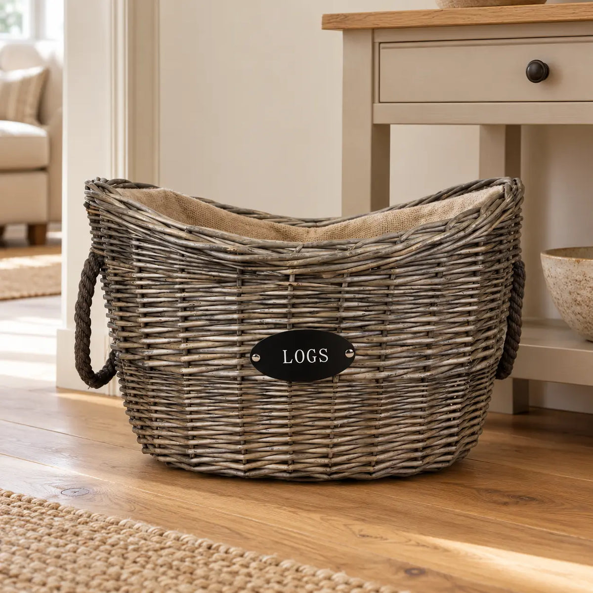 Empty Meon oval log basket beside a neutral console