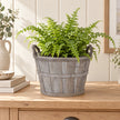 Small Meon planter basket holding a fern on a pale oak console