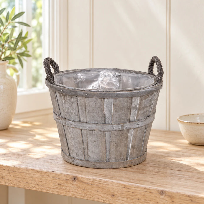 Empty small Meon planter basket with clear liner on an oak shelf