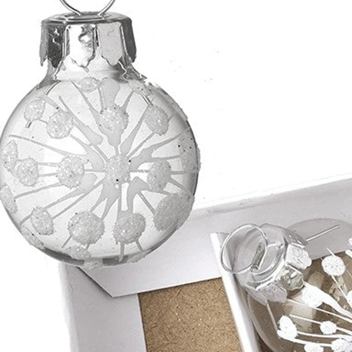 Close-up of white glitter snowburst design on clear mini glass Christmas bauble with silver cap