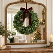 Mistletoe wreath hanging against an antique gold mirror