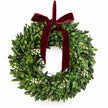 Christmas mistletoe wreath with burgundy bow, lush green foliage, and festive decorations, designed by Satchville.