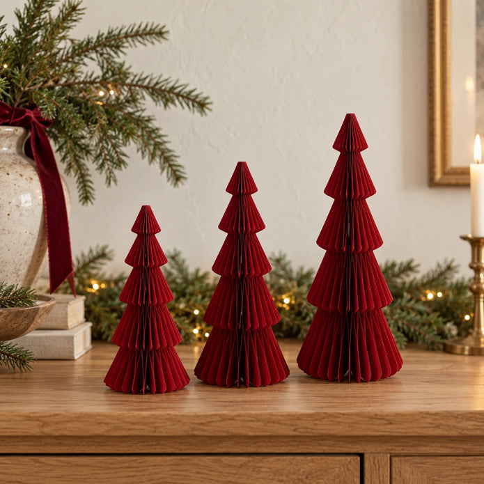 Three burgundy red standing paper trees in 20cm, 25cm and 30cm heights on an oak Christmas sideboard.