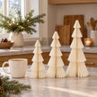 winter white paper tree set in three heights beside a mug of tea in a country kitchen.