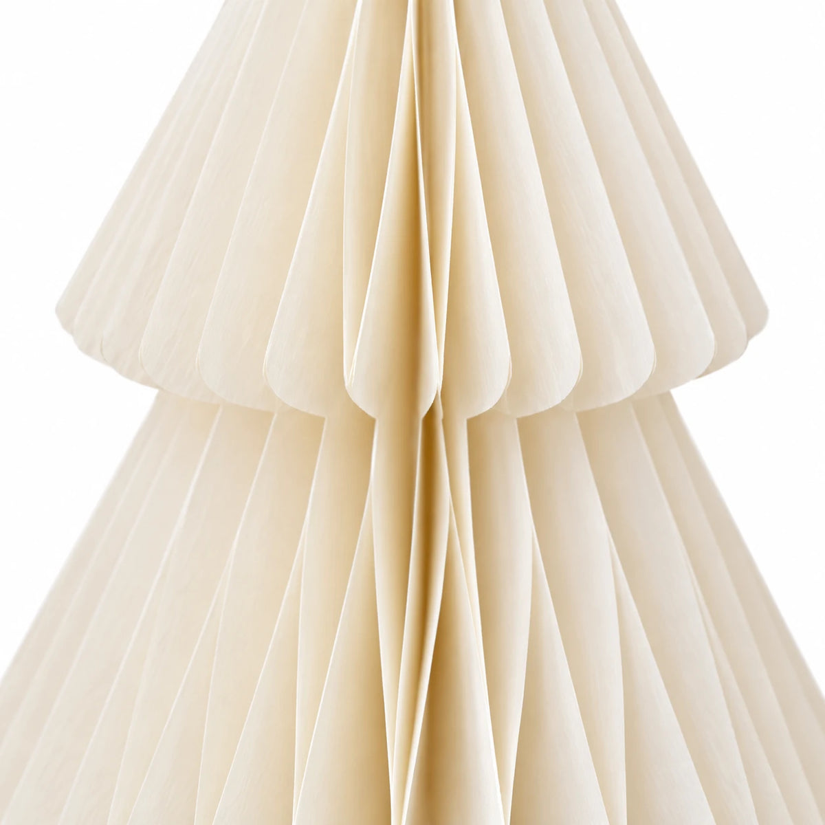 Close-up of winter white folded paper and tier edges on a standing Christmas tree.