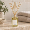 Heaven Scent MOROCCAN ROSE 100ml reed diffuser styled on a stone bathroom shelf with reeds inserted.