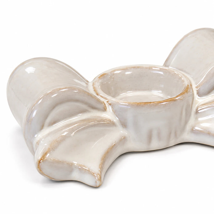 Close-up of the empty tealight cup and ivory glazed ceramic bow folds