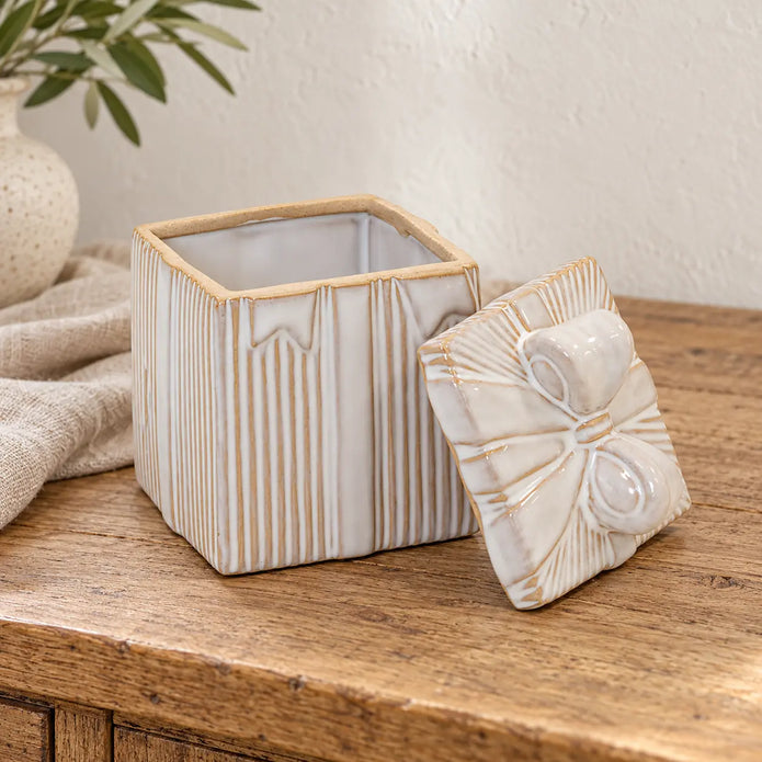 Cream glazed ceramic gift box displayed open on a rustic wooden sideboard