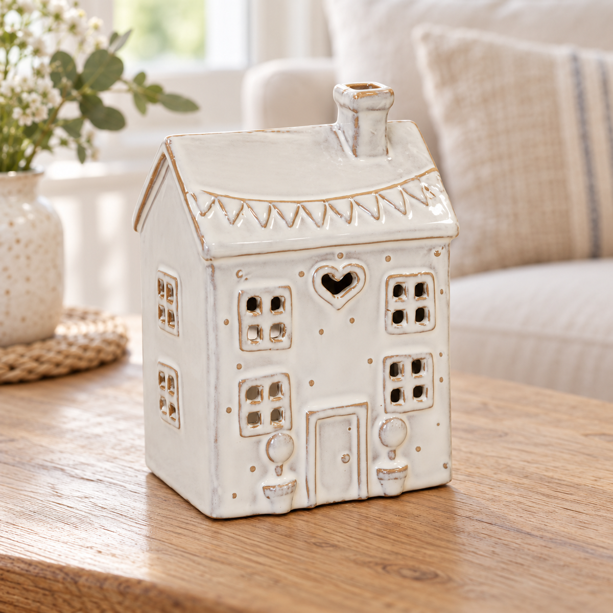 Natural ceramic heart house tealight holder unlit on an oak side table