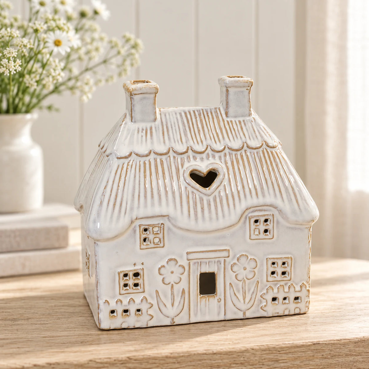 Natural ivory ceramic thatch roof tealight house, 16cm wide, hero view, shown empty.
