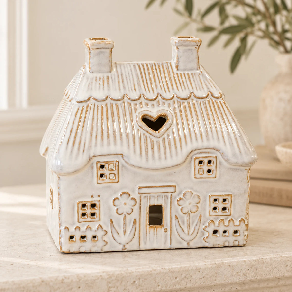 Natural ivory ceramic thatch roof tealight house, 16cm wide, mantel view, shown empty.