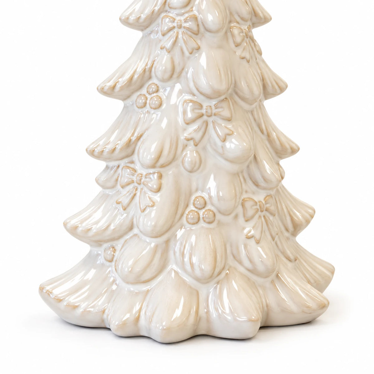 Close-up of raised bows, baubles and layered branches on the ivory ceramic Christmas tree against white.