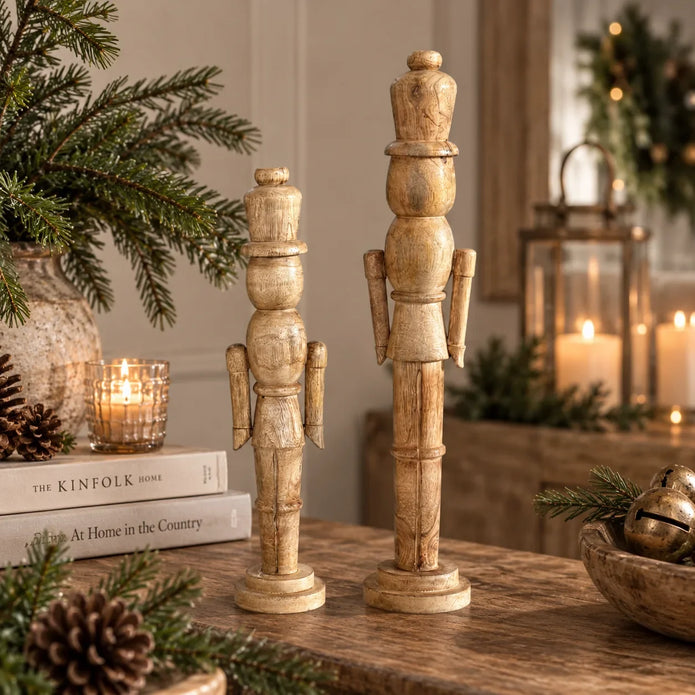 Medium and large natural wooden nutcracker decorations in a neutral Christmas home setting, photograph 1