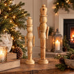 Medium and large natural wooden nutcracker decorations in a neutral Christmas home setting, photograph 4