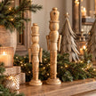 Medium and large natural wooden nutcracker decorations in a neutral Christmas home setting, photograph 5