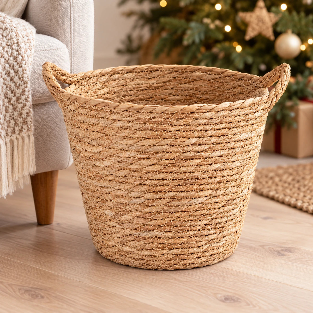 Empty natural woven basket with handles beside an armchair in a neutral Christmas room