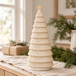 Neutral ceramic Christmas tree on a linen-lined sideboard; props not included