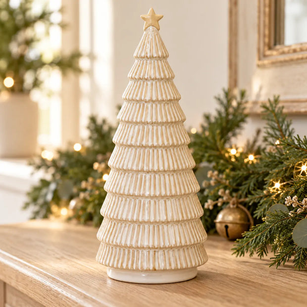 Satchville neutral ceramic Christmas tree with painted branches and small colorful ornaments on a wooden surface.