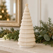 Ribbed cream ceramic Christmas tree on a pale stone mantel; props not included