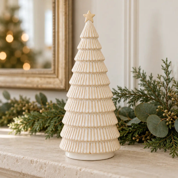 Satchville neutral ceramic Christmas tree with colorful ornaments on a stone mantel, festive holiday decor for Christmas.