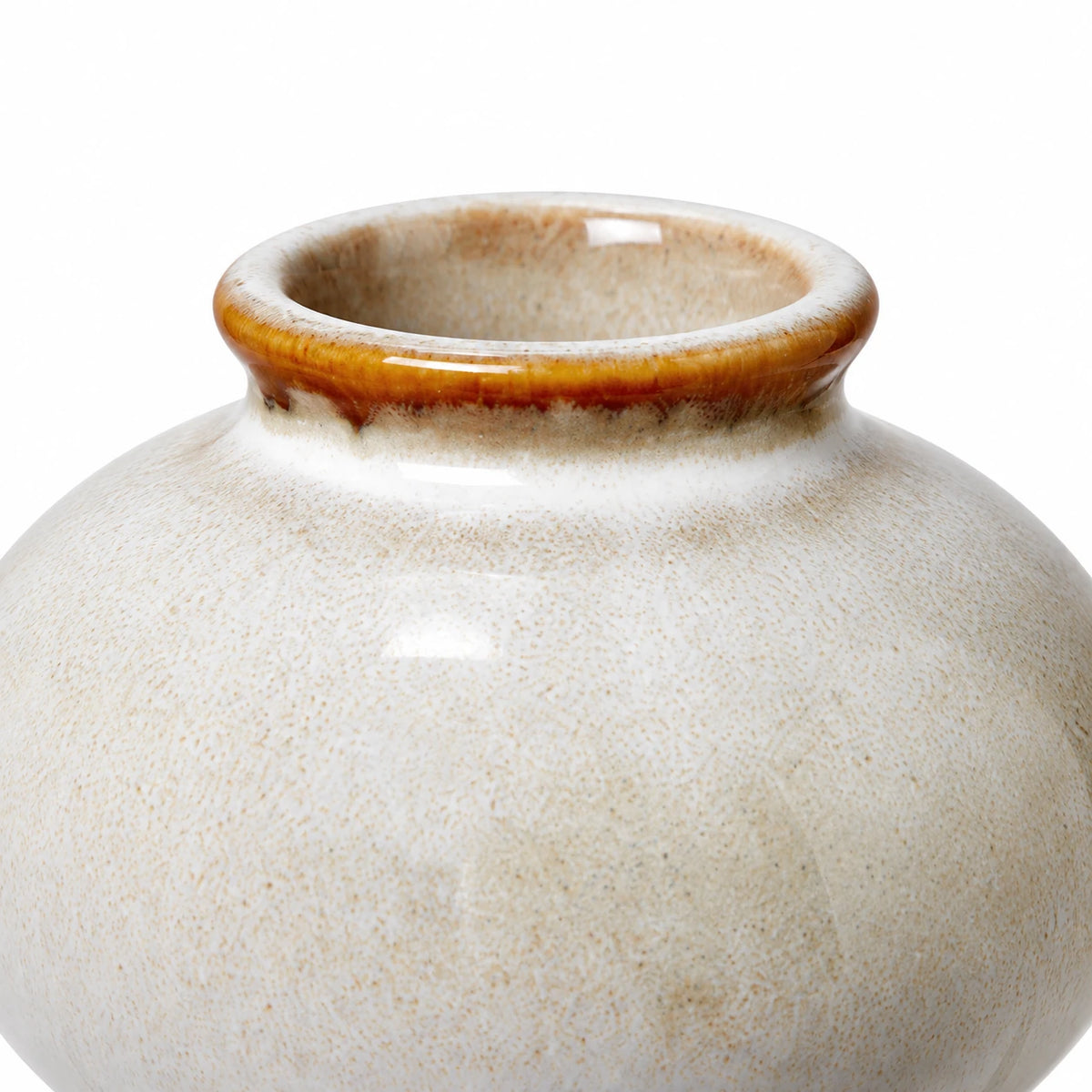Close-up of the small ceramic bud vase showing its brown glazed rim and glossy cream speckled finish.