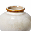 Close-up of the small ceramic bud vase showing its brown glazed rim and glossy cream speckled finish.