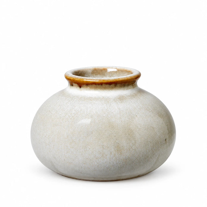 Small neutral ceramic mini bud vase with a rounded cream speckled body and brown glazed rim, shown empty on white.