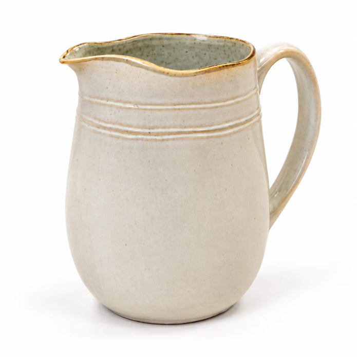 Studio view of neutral stoneware jug showing grey-green interior and warm-toned rim