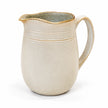 Cream stoneware jug with curved handle and banded rim on a white background