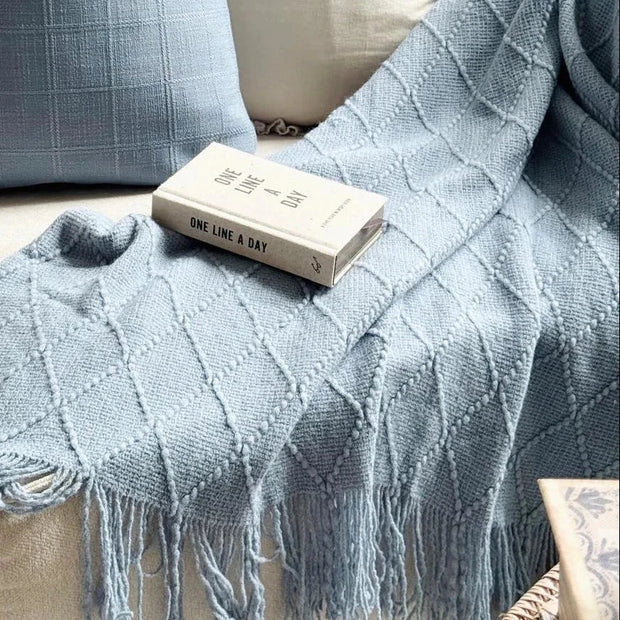 Ocean Blue Diamond Pattern Knitted Throw, blue diamond-knit throw with tassels draped over a sofa