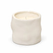 Off-white Satchville sculpted candle for home decor, featuring intricate carved design and elegant shape.