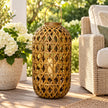 Medium oval bamboo lantern with glass insert and LED candle prop on a summer veranda