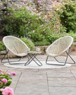 Cream rattan Snug garden furniture chair and table set by Pacific Lifestyle Ltd, featuring natural woven design for outdoor relaxation.