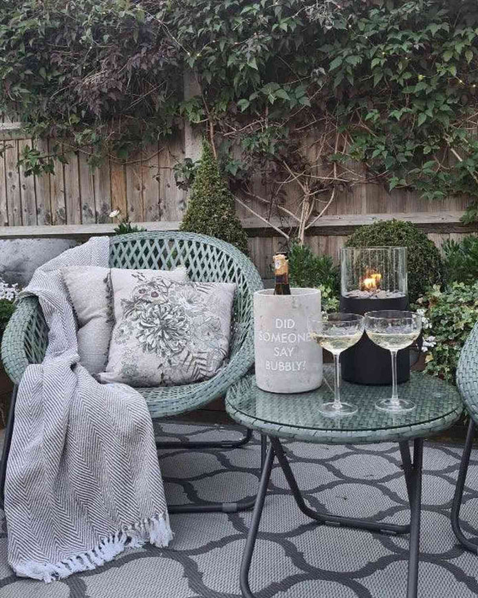 Green rattan garden furniture set with chair and table from Pacific Lifestyle Ltd, ideal for outdoor relaxation.