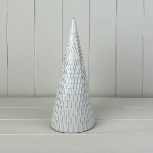 White glazed ceramic cone-shaped Christmas tree with textured vertical detailing on a pale tabletop