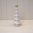 Large stone glazed ceramic Christmas tree with cream bow on top, decorated for holiday season, by Satchville.