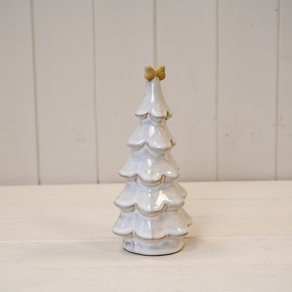 Medium stone glazed ceramic Christmas tree by Satchville with cream bow on top, decorated with colorful ornaments and lights.