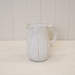 Large natural ceramic jug with petal-shaped design, ideal for home decor, by Satchville.