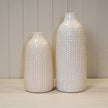 White leaf-patterned ceramic vase with a glossy finish and narrow bottle-shaped neck