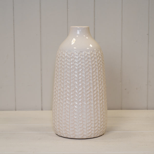 White leaf-patterned ceramic vase with a glossy finish and narrow bottle-shaped neck