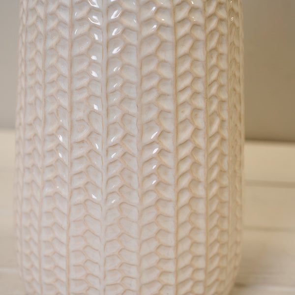 White leaf-patterned ceramic vase with a glossy finish and narrow bottle-shaped neck