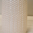 White leaf-patterned ceramic vase with a glossy finish and narrow bottle-shaped neck