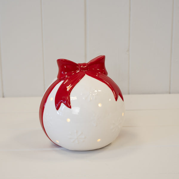 White Christmas bauble with red bow, decorative holiday ornament by Satchville, featuring festive red and white holiday design.