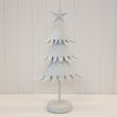 White metal extra tall Satchville Christmas tree decorated with ornaments and lights for holiday festivities.