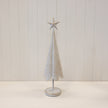 Large white metal Christmas tree with gold star detailing and round base