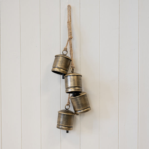 Gold metal cowbell hanging garland for Christmas decorations, featuring multiple cowbells on a string, by Satchville.