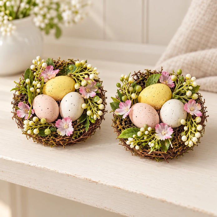 Set of two decorative pastel egg nests with pink flowers and greenery, packaging removed, shelf view.